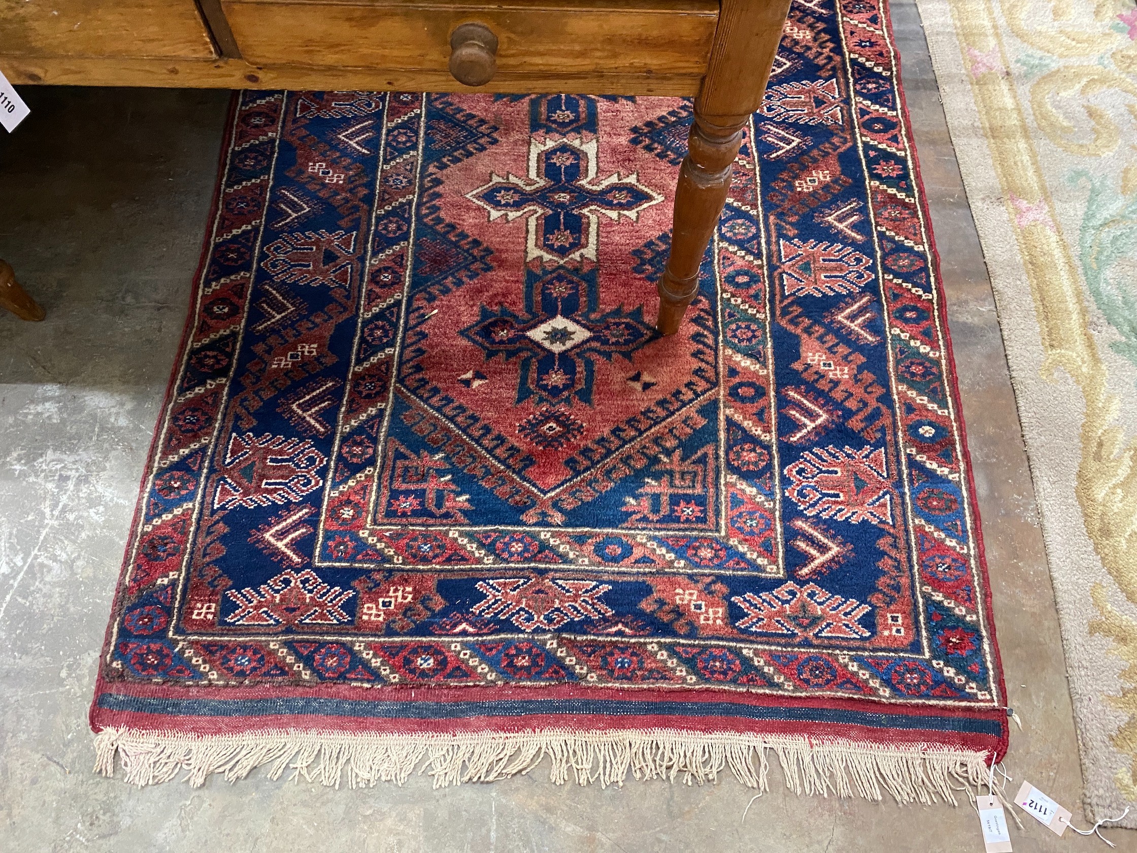 A Caucasian style red ground rug, 184 x 130cm